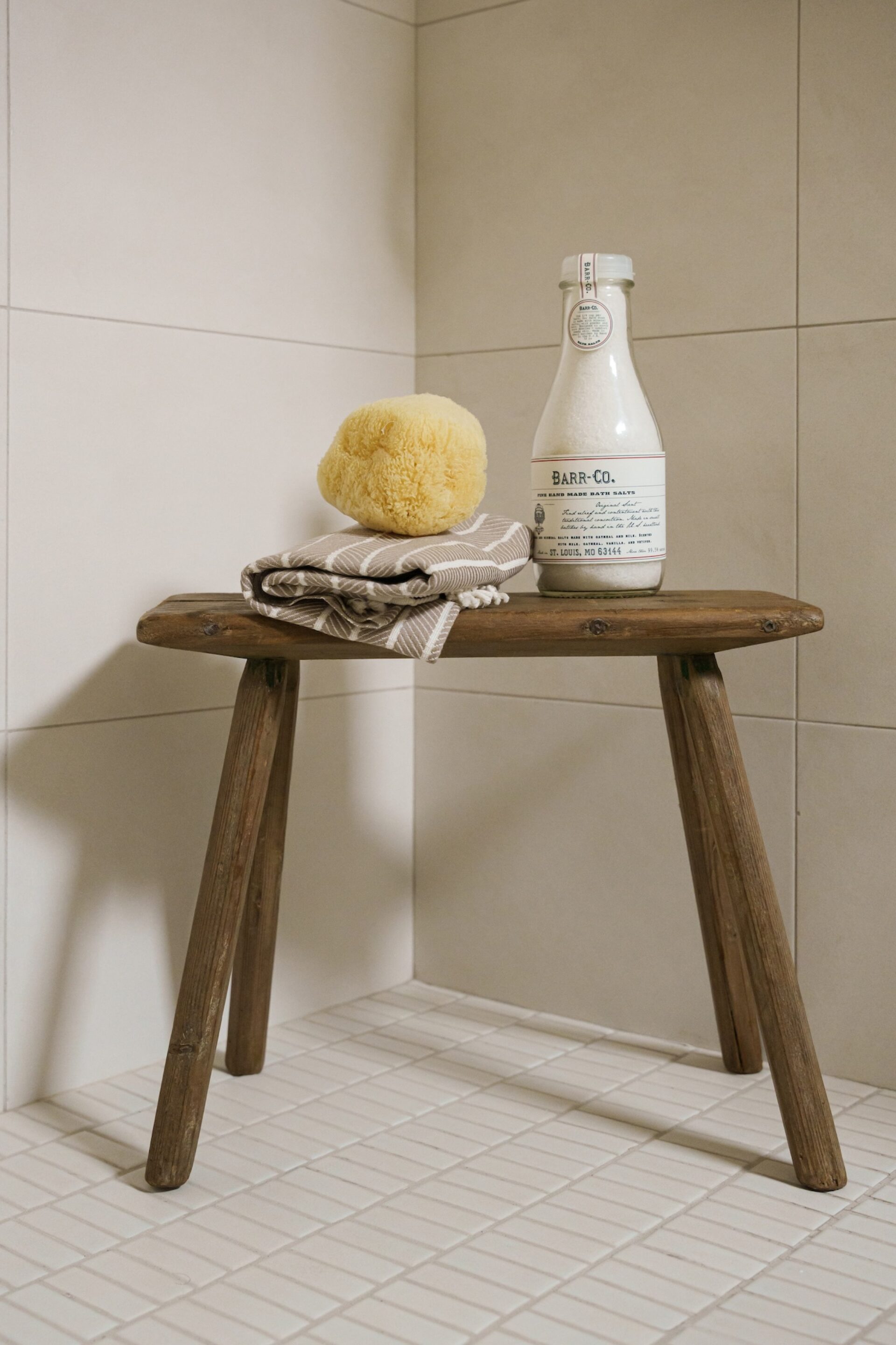 Small Wooden Stool In White Tile Shower