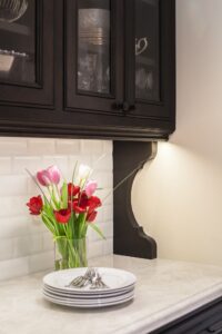 White Plates Stacked Next To Vase Of Tulips